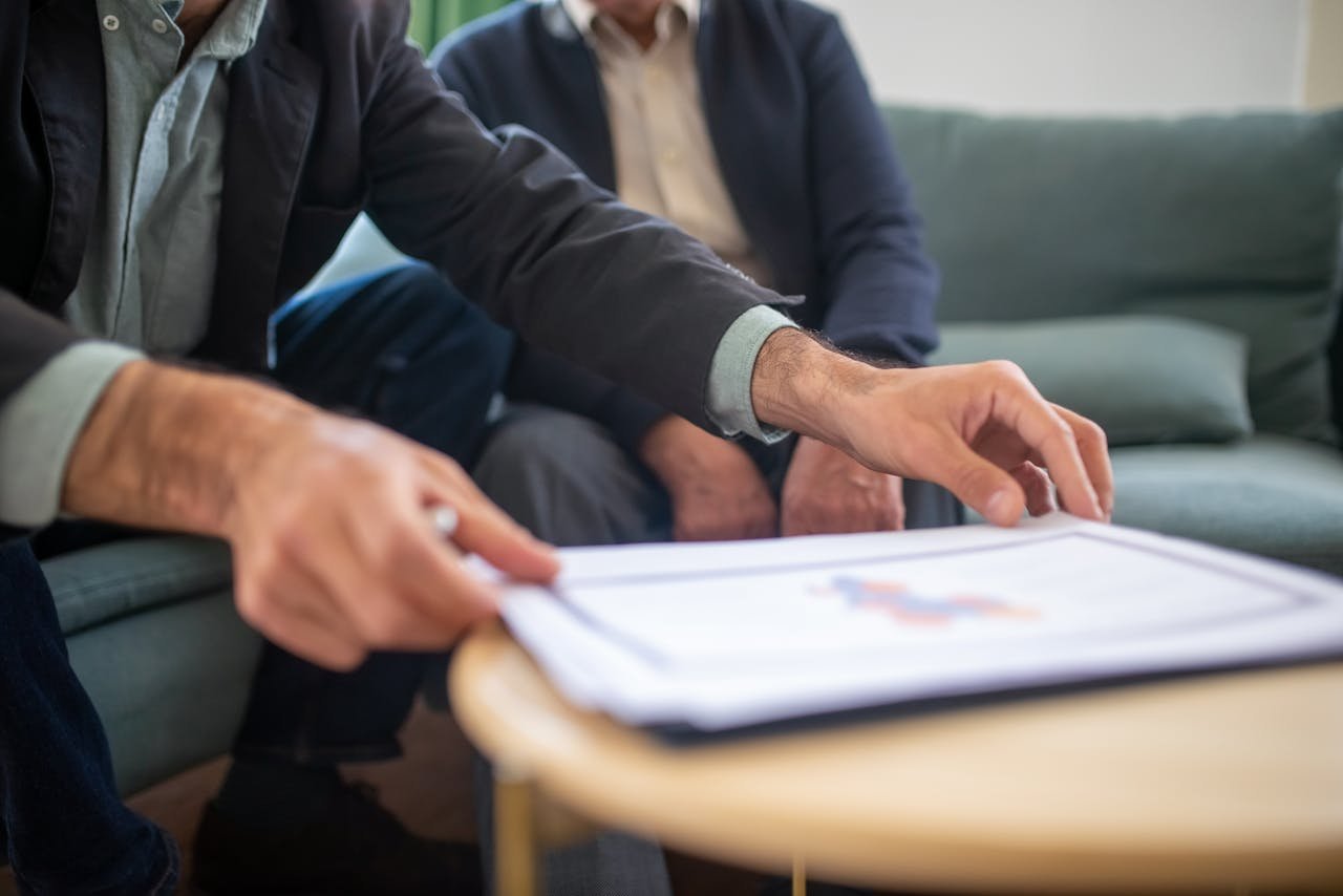 services-01 Two men discussing documents during a business meeting, focusing on paperwork.